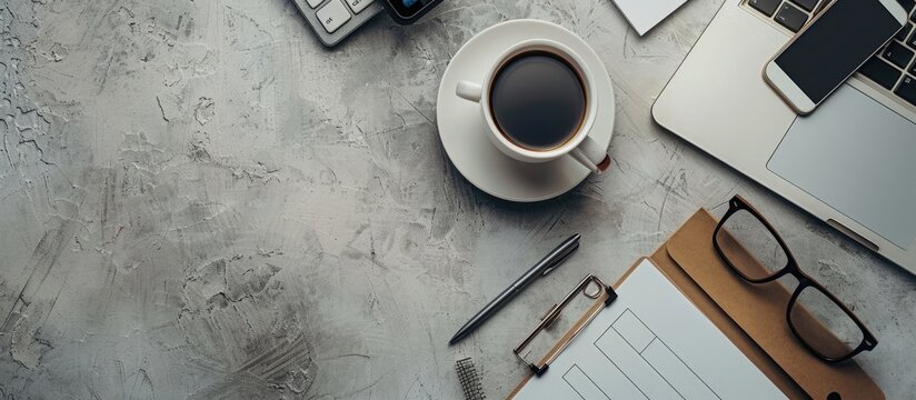 Elegant modern freelancer workspace showcasing office desk items like a clipboard, keyboard, coffee cup, smartphone, notepad, and pen from a top view with a copy space image in a flat lay arrangement.