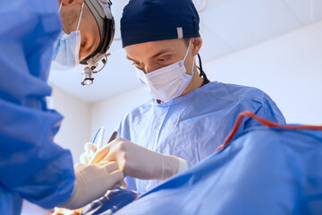male surgeons perform surgery in operating room, plastic surgeon in operating room