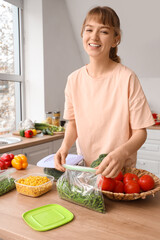 Beautiful young woman with vegetables for freezing in kitchen