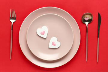 Beautiful table setting with hearts on red background. Valentine's Day celebration