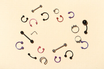 Frame made of stylish jewelry for piercing on color background