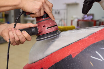 Person using a machine to polish automotive lighting on a car headlight