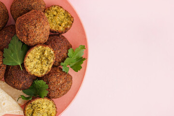 Plate with delicious falafel balls and parsley on pink background, closeup