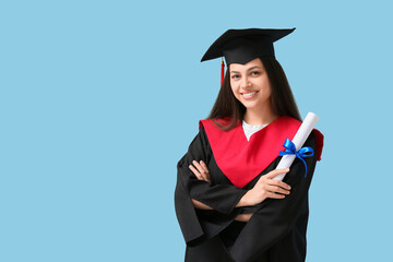 Happy female graduate with diploma on blue background