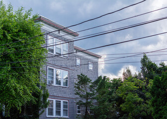 Power lines and urban residence against overcast sky in Brighton, Massachusetts, USA