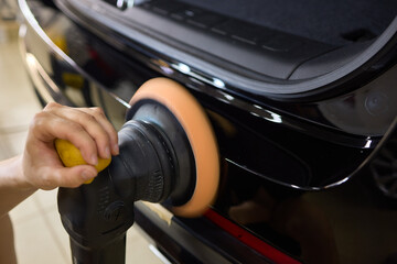 Obraz premium Car detailing enhances shine of vehicle with machine buffer for glossy finish