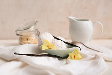 Bowl of sweet vanilla ice-cream balls with sticks and flowers on white background