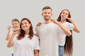 Fototapeta premium Happy family brushing teeth on light background