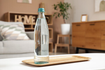Bottle of water on table in living room, closeup