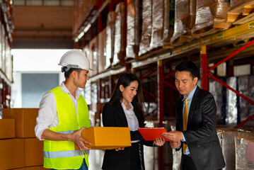 Group of Asian Business people and warehouse worker meeting and discussion during loading inventory stock in distribution fulfillment center. Freight transportation logistic cargo business concept.