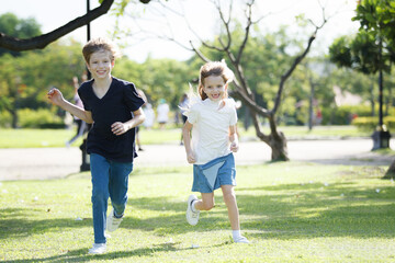 Naklejka premium Lovely little children playing or running together at park.