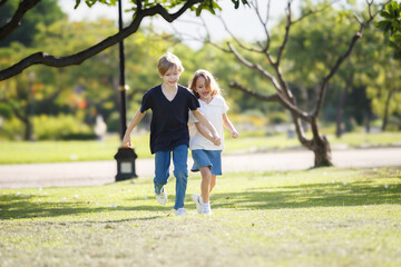Fototapeta premium Lovely little children playing or running together at park.
