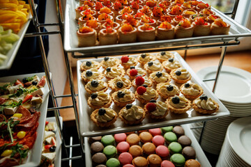 Gourmet Dessert Buffet - big selection of tartlets, cream pastries, and macarons at an elegant catering event