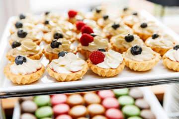The set of mini tartlets topped with luscious cream and ripe berries.