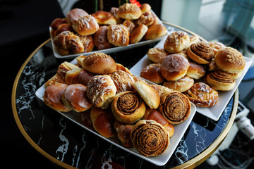 Freshly baked cinnamon pastries are displayed on a two-tiered serving tray.