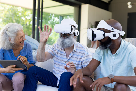 At home, Diverse group of senior friends using VR headsets and tablet, enjoying technology - Powered by Adobe
