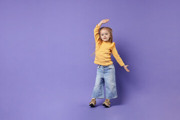 Cute little girl dancing on purple background, space for text