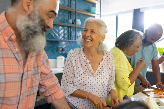 At home, Diverse group of senior friends cooking together, enjoying time in kitchen