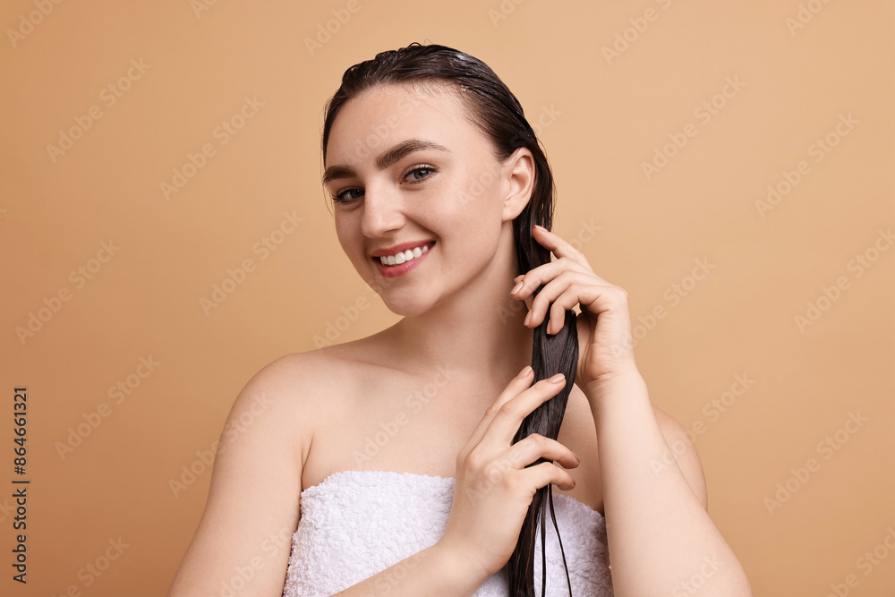 Poster Smiling woman applying hair mask on beige background