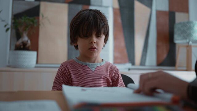 Child reluctant and struggling with learning, showing frustration and difficulty during a learning activity, highlighting the challenges of education in a supportive home environment