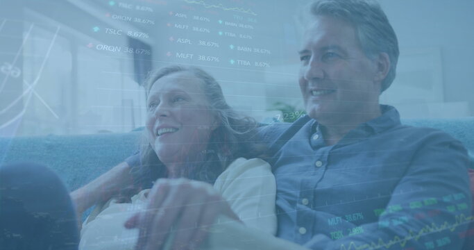 Image of graphs and trading boards over senior caucasian couple spending quality time at home