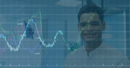 Image of financial data processing against portrait of biracial man smiling at office