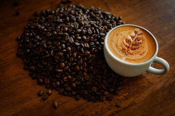 Beautiful latte, coffee beans and wood background, in a cozy coffee shop