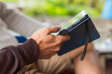 A man's hand is playing with a smartphone