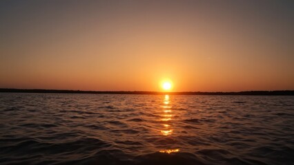 sunset over a body of water with the sun setting in the middle of the sky