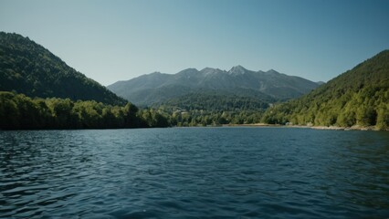 Fototapeta premium large body of water surrounded by trees and a mountain range with a small town in the distance