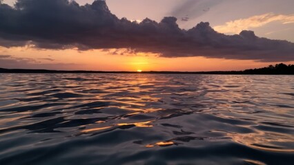 Obraz premium body of water with a sunset in the background and clouds reflected in the water