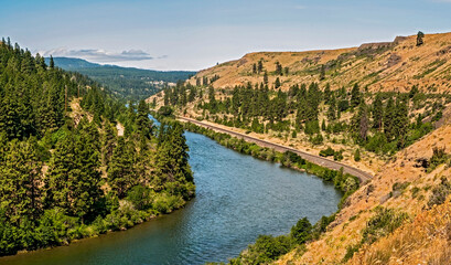 A panoramic view looking downriver on the Yakima River Canyon Scenic Byway in Washington state on a beautiful summer day with the brown hillsides and trees lining the river_07072009_