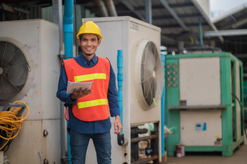 Asian engineer diligently inspects machinery in an industrial factory.Asian workers diligently...