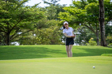 Professional woman golfer teeing golf in golf tournament competition at golf course for winner	