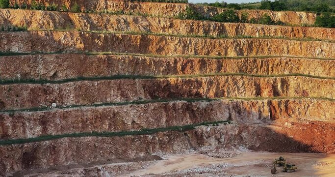 Large mine of surface mining pit on mountain hillside with a large hole in the middle made of dirt and rocks