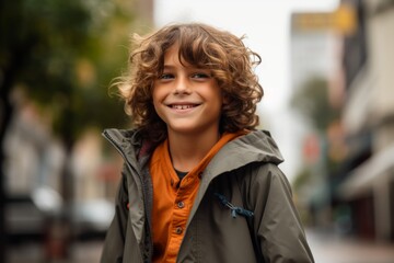portrait of smiling boy in autumn coat on city street, outdoors