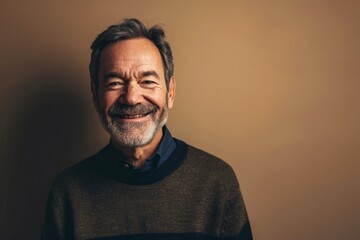 Fototapeta premium Portrait of a happy senior man smiling at the camera on a neutral background