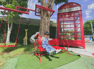 Children playing happily on a colorful playground in a sunny park filled with slides, swings, and...