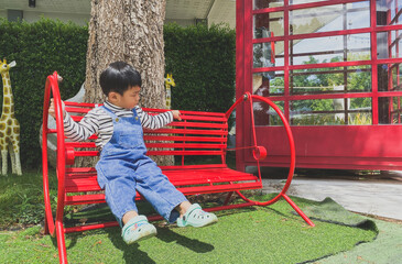 Children playing happily on a colorful playground in a sunny park filled with slides, swings, and...
