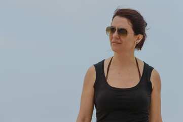 Retrato de mujer latina al natural con lentes estilo aviador y vestida de negro.