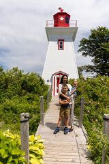 Mother and children in front of lighthouse 