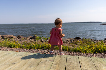 Toddler girl on path in front of ocean 