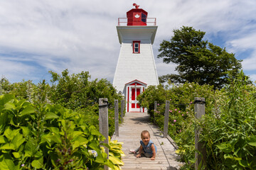 Toddler girl in front of light house 