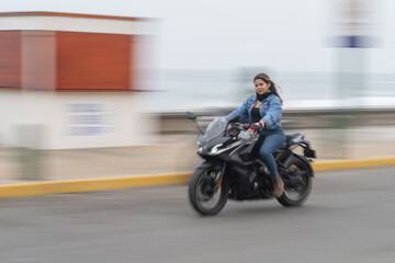 Photo with motion of a woman driving a motorbike
