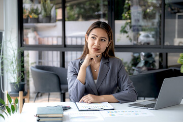 Businesswomen bookkeepers use a hand-held laptop to analyze the graph to set challenging business goals and be ready to achieve targets at home.