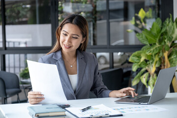 Businesswomen bookkeeper use laptop analysis the graph for Setting challenging business goals and...