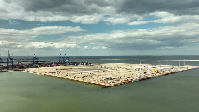 Aerial view of a large industrial port area under a cloudy sky in Gdańsk, Poland