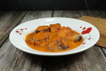 Traditional fried red curry soup with fresh fish fillet serving on the plate. Famous hot and spicy seafood menu in Thai restaurant. 