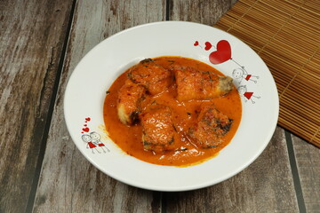 Traditional fried red curry soup with fresh fish fillet serving on the plate. Famous hot and spicy seafood menu in Thai restaurant. 