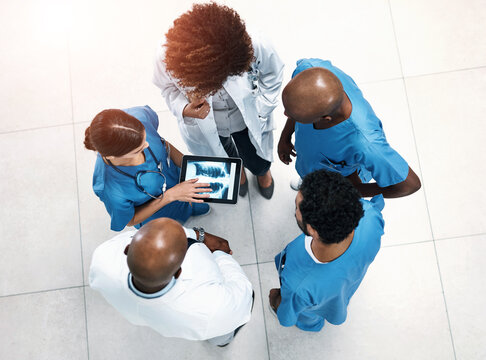 Top view, tablet screen and doctors in lobby, xray or teamwork for surgery feedback. Specialist, medical or professional with tech, advice or collaboration for healthcare, review results or people